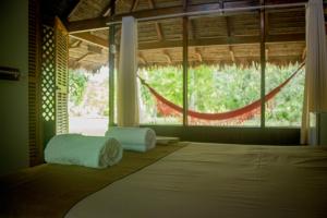Zimmer mit einem Bett und einem großen Fenster in der Unterkunft La Habana Amazon Reserve in Puerto Maldonado