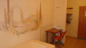 a room with a desk and a painting on the wall at StadtHotel Passau in Passau