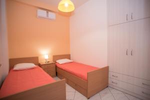 a bedroom with two beds and a cabinet and lights at Comfi apartment Kleio in Heraklio Town