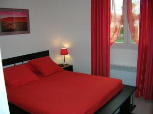 1 dormitorio con cama roja y ventana en Gîte Dieppe, en Auppegard