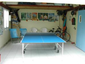 stół do ping ponga w pokoju z 2 krzesłami w obiekcie Gîte Dieppe w mieście Auppegard