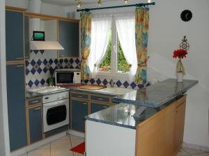 een keuken met een wastafel en een fornuis top oven bij Gîte Dieppe in Auppegard