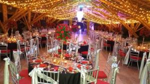 a banquet hall with tables and chairs with lights at Hotel Campestre el Fuerte in Rozo