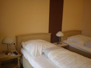 1 dormitorio con 2 camas y 2 mesas con lámparas en Hotel zur Küferschenke en Nierstein