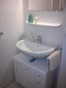 Baño blanco con lavabo y espejo en Hotel zur Küferschenke, en Nierstein