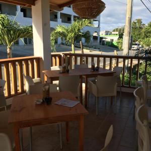 two tables and chairs on a patio with a balcony at Casita Blanca Bayahibe in Bayahibe
