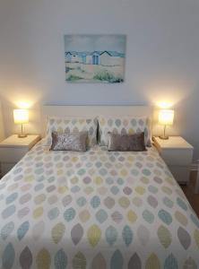 a bedroom with a large bed with two lamps at Orchid House Clifden in Clifden