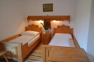 two twin beds in a room with a table at Pension Hinterleithner in Persenbeug