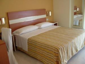 a bedroom with a large bed with a wooden headboard at Hotel GF in Cesano Boscone