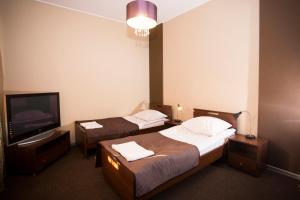 um quarto de hotel com duas camas e uma televisão em Noclegi M4 em Żyrardów