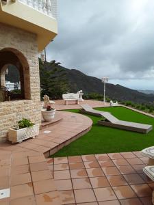 a patio with a bench and grass at Holiday Home Hemi in Valsequillo
