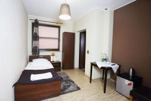 Un dormitorio con una cama y una mesa. en Noclegi M4, en Żyrardów