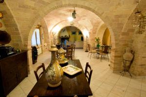 a dining room with a table with a vase on it at La Casa Del Palombaro in Ortona