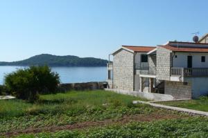 a house next to a body of water at Apartments Gabrijela in Prizba