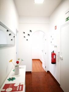 a hallway with a white room with birds on the wall at Peniche's Blue & White in Peniche