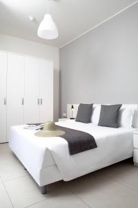 a white bedroom with a large white bed at Palazzo Talenti 1907 in Trieste