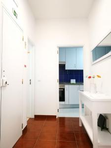 a kitchen with white cabinets and a white sink at Peniche's Blue & White in Peniche +27 photos