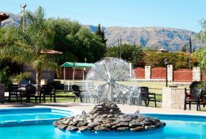 una fuente de agua con una noria en una piscina en Hotel Torres del Sol en Merlo