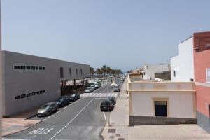 ulica miejska z samochodami zaparkowanymi na ulicy w obiekcie Apartamentos Castillo Mar Gran Canaria w mieście Castillo del Romeral