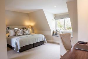 
a hotel room with a bed, chair, and nightstand at Spicers Clovelly Estate in Montville
