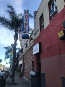 a building with a hotel sign and a palm tree at Hotel West Inn, Hollywood - LA in Los Angeles