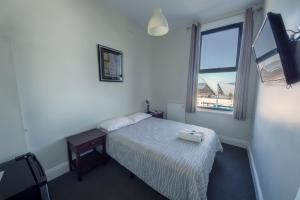 アルバニーにあるSix Degrees Boutique Hotelの小さなベッドルーム(ベッド1台、窓付)