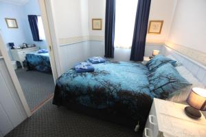 
a hotel room with a bed and a desk at Jacaranda Guest House in Busselton
