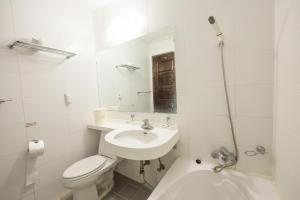 a white bathroom with a toilet and a sink at Daea Ulleung Resort in Ulleung