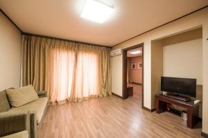 uma sala de estar com um sofá e uma televisão em Daea Ulleung Resort em Ullŭng