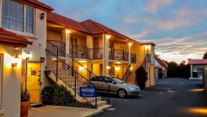 a car parked in a parking lot in front of buildings at Northcote Motor Lodge in Christchurch