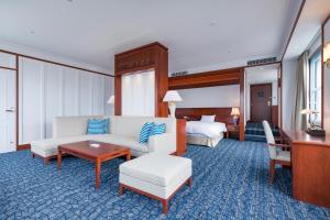 北九州市にあるプレミアホテル門司港のベッド2台とリビングルームが備わるホテルルームです。