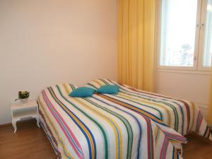 Un dormitorio con una cama con dos almohadas y una ventana. en Huoneistohotelli Nallisuites, en Oulu
