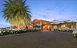 a large white house with palm trees and palm trees at Strathearn Park Lodge in Scone