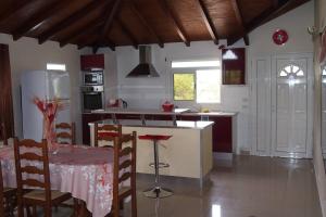 cocina con mesa y nevera en Haut de villa, en Sainte-Rose