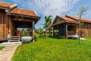 a house with a green lawn in front of it at Kampot River Residence in Kampot