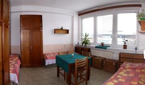 a room with a table and two beds and a window at Hostel Modrá in Prague