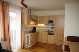 a small kitchen with wooden cabinets and a window at Ulnhof in Mariapfarr