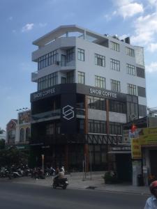 - un grand bâtiment blanc avec un panneau dans l'établissement The MONDAY APARTMENT, à Hô-Chi-Minh-Ville