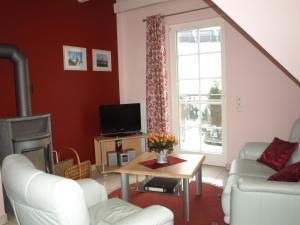 a living room with a white couch and a window at Aalkoje Ostseebad Wustrow in Wustrow