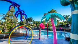 een zwembad in een resort met kleurrijke glijbanen bij Ingenia Holidays Wairo Beach in Lake Tabourie