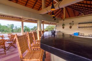 a bar in a restaurant with chairs and tables at Karma Traders Kampot in Kampot