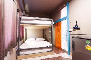a small room with a bunk bed in it at Merge Hostel in Bangkok