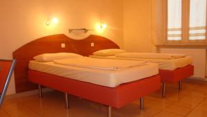 
a hotel room with two beds and two lamps at StadtHotel Passau in Passau
