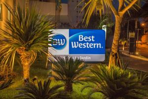 um sinal do melhor oeste em frente a algumas palmeiras em Best Western Suites Le Jardin Caldas Novas em Caldas Novas