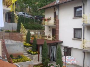 a building with a staircase and flowers in a yard at Guest House Rusalka in Shipkovo