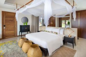 a bedroom with a white bed with a canopy at Sofitel Inle Lake Myat Min in Ywama