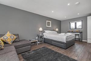 a bedroom with a bed and a couch and a desk at Paddock Drive in Winchester