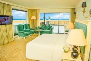 a hotel room with a bed and a view of the ocean at The Kingsbury Colombo in Colombo