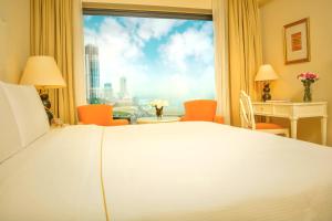 - une chambre avec un lit et une grande fenêtre dans l'établissement The Kingsbury Colombo, à Colombo