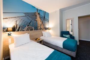 Un pat sau paturi într-o cameră la Hotel Eureka